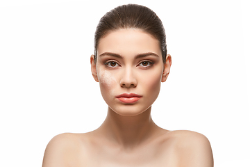 Image showing girl applying powder on face isolated on white