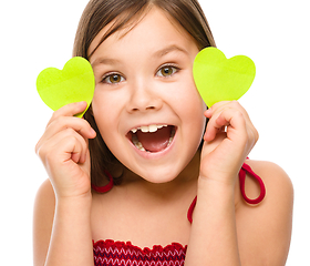 Image showing Little girl is holding hearts near her eyes