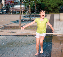 Image showing Girl is running through fountains