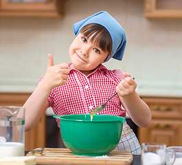 Image showing Girl is cooking in kitchen