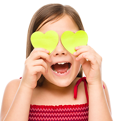 Image showing Little girl is holding hearts over her eyes