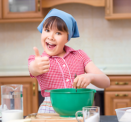 Image showing Girl is cooking in kitchen