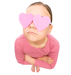 Image showing Little girl is holding hearts over her eyes