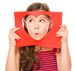 Image showing Little girl is looking through heart template