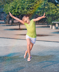 Image showing Girl is running through fountains