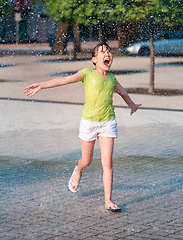 Image showing Girl is running through fountains