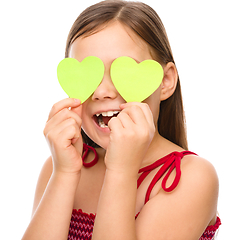 Image showing Little girl is holding hearts over her eyes