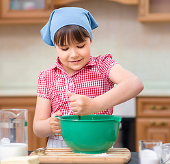 Image showing Girl is cooking in kitchen