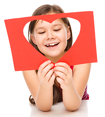 Image showing Little girl is looking through heart template