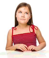 Image showing Girl is writing on color stickers using pen