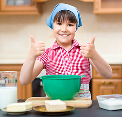 Image showing Girl is cooking in kitchen