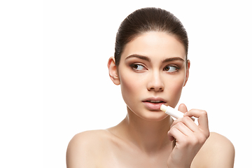 Image showing girl applying pink lipstick isolated on white