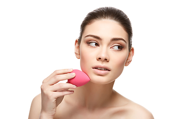 Image showing girl with makeup sponge isolated on white