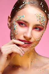 Image showing beautiful girl with candies on pink backgroound