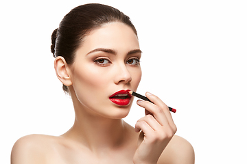 Image showing girl applying red lipstick isolated on white