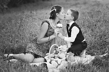 Image showing Little boy and teen age girl having picnic outdoors