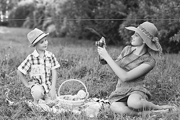 Image showing Little boy and teen age girl having picnic outdoors