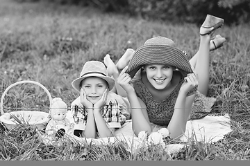 Image showing Little boy and teen age girl having picnic outdoors