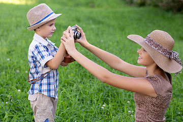 Image showing handsome little boy with retro camera and girl model