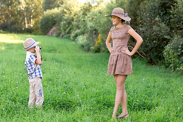 Image showing handsome little boy with retro camera and girl model