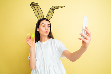 Image showing Easter bunny woman with bright emotions on yellow studio background