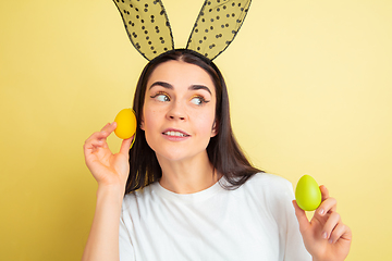 Image showing Easter bunny woman with bright emotions on yellow studio background