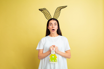 Image showing Easter bunny woman with bright emotions on yellow studio background