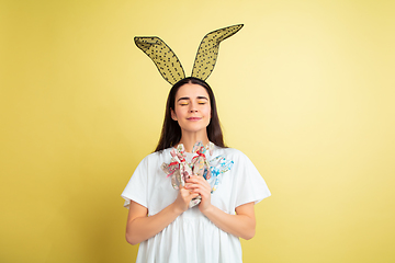 Image showing Easter bunny woman with bright emotions on yellow studio background