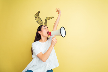 Image showing Easter bunny woman with bright emotions on yellow studio background