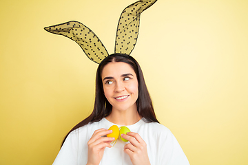 Image showing Easter bunny woman with bright emotions on yellow studio background