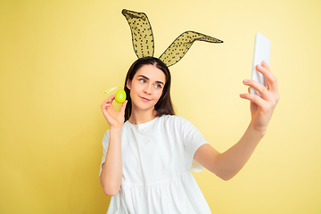 Image showing Easter bunny woman with bright emotions on yellow studio background