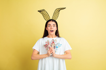 Image showing Easter bunny woman with bright emotions on yellow studio background