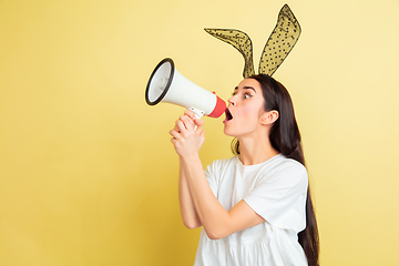 Image showing Easter bunny woman with bright emotions on yellow studio background