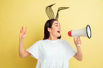 Image showing Easter bunny woman with bright emotions on yellow studio background