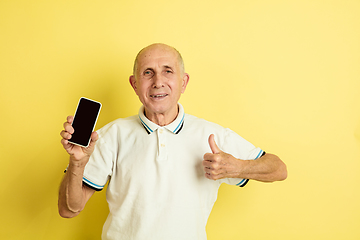 Image showing Caucasian senior man\'s portrait isolated on yellow studio background