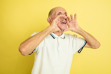 Image showing Caucasian senior man\'s portrait isolated on yellow studio background