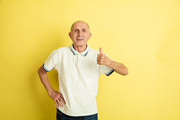 Image showing Caucasian senior man\'s portrait isolated on yellow studio background