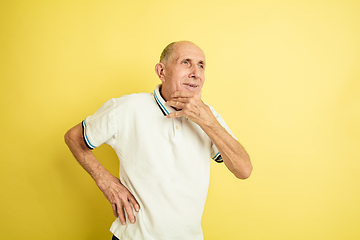 Image showing Caucasian senior man\'s portrait isolated on yellow studio background