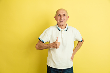 Image showing Caucasian senior man\'s portrait isolated on yellow studio background