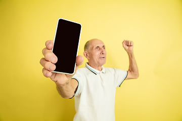 Image showing Caucasian senior man\'s portrait isolated on yellow studio background