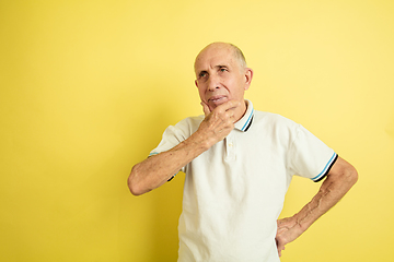 Image showing Caucasian senior man\'s portrait isolated on yellow studio background