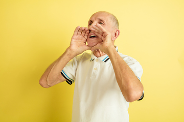 Image showing Caucasian senior man\'s portrait isolated on yellow studio background