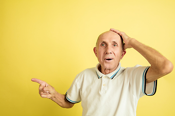 Image showing Caucasian senior man\'s portrait isolated on yellow studio background