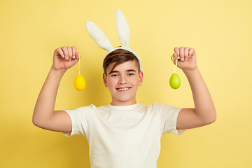 Image showing Easter bunny boy with bright emotions on yellow studio background