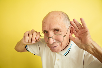 Image showing Caucasian senior man\'s portrait isolated on yellow studio background