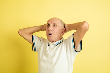 Image showing Caucasian senior man\'s portrait isolated on yellow studio background