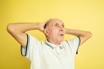 Image showing Caucasian senior man\'s portrait isolated on yellow studio background