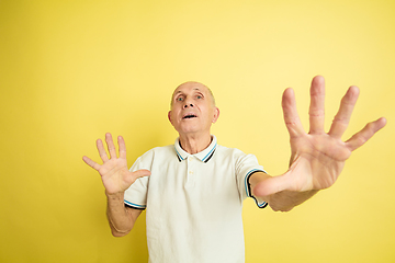 Image showing Caucasian senior man\'s portrait isolated on yellow studio background