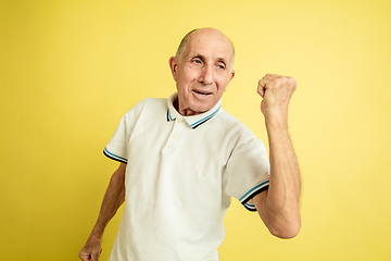 Image showing Caucasian senior man\'s portrait isolated on yellow studio background