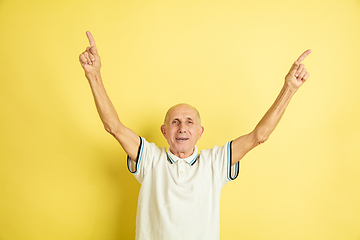 Image showing Caucasian senior man\'s portrait isolated on yellow studio background